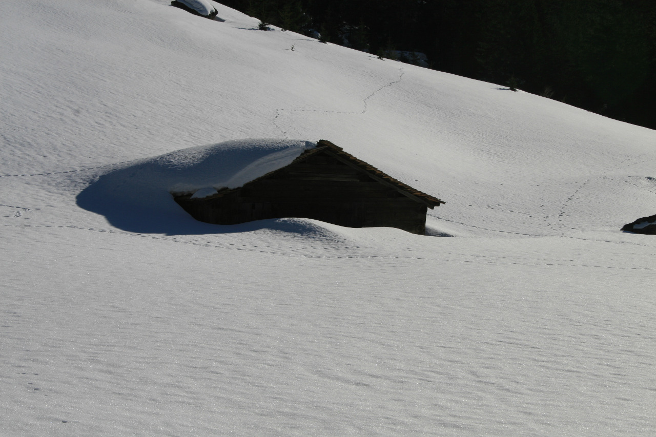 eine eingeschneite Berghütte